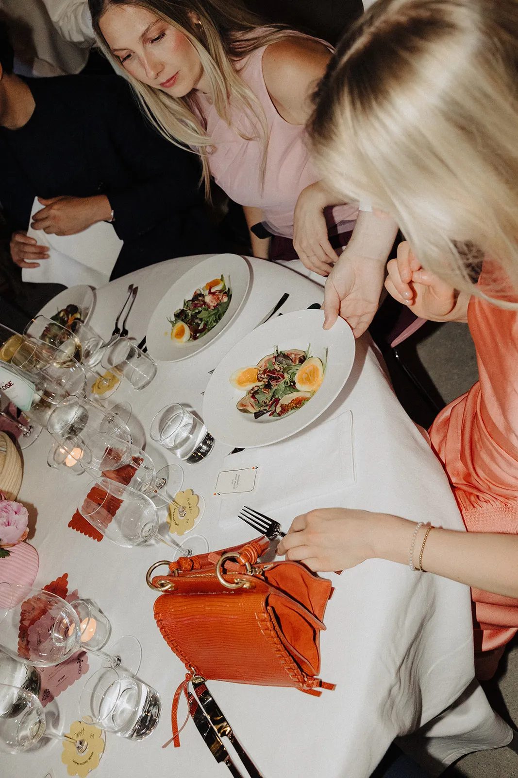 Guests laughing over dinner, seen from above across the table