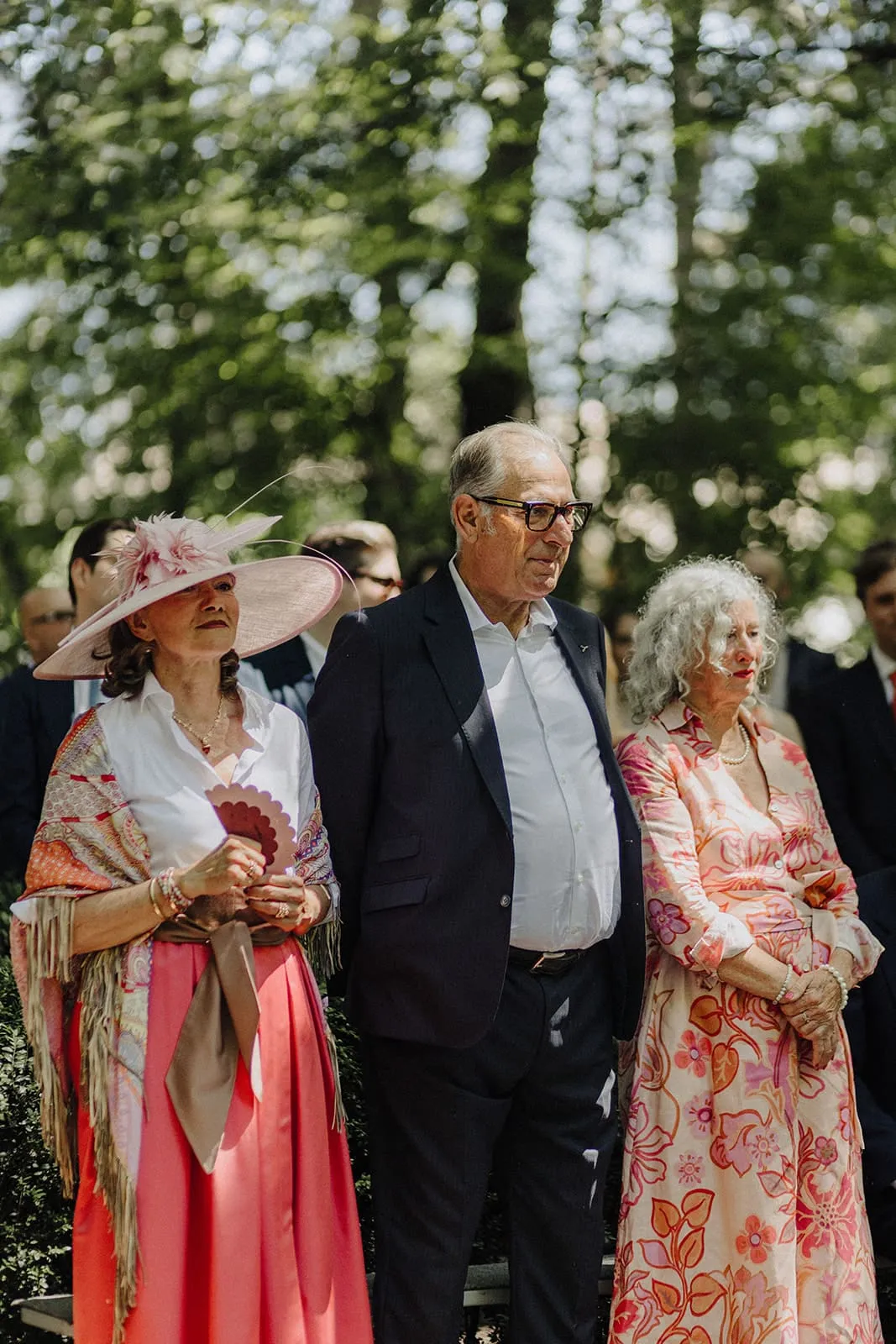 Three older guests standing through the ceremony